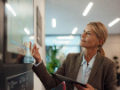 Businesswoman with tablet PC looking at screen in office.