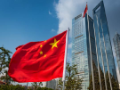 Chinese flag flying beside futuristic Shanghai skyscrapers