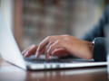 Close up hands typing on a laptop