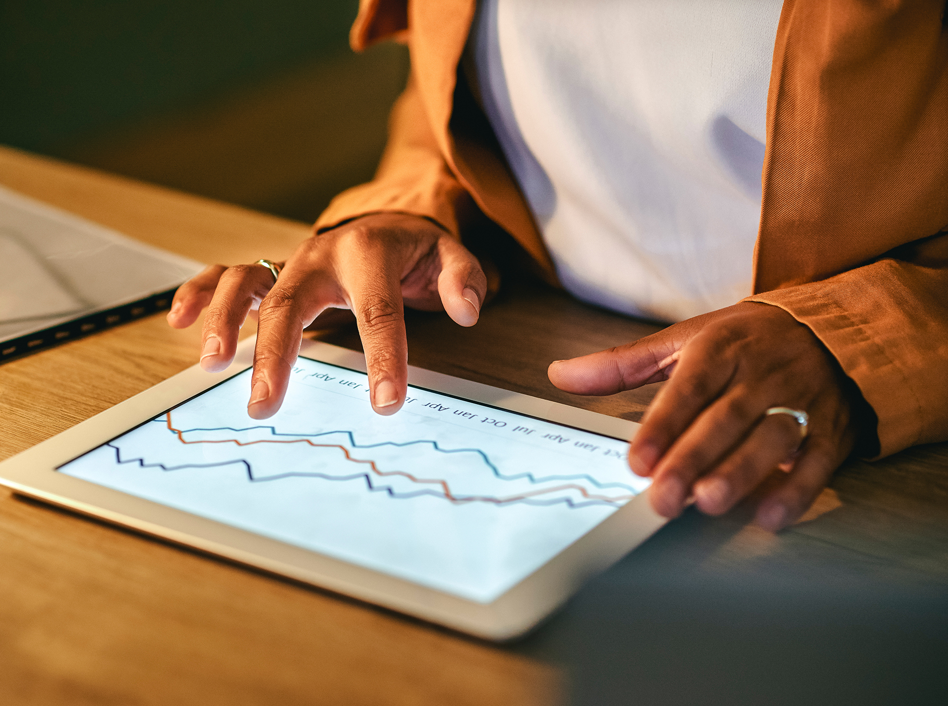 diverse businesswoman working on a tablet screen analyzing graphs