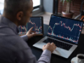 Man Checking His Stock Market Exchange Investment Using His Laptop Computer.