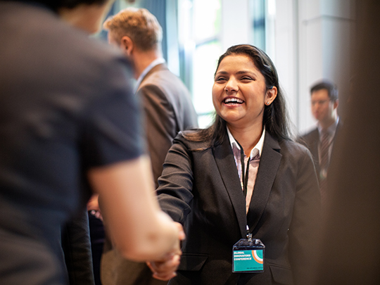 business professionals greeting each other at conference.