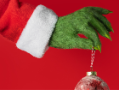 Grinch hand holding ornament.
