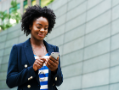 Woman in a blue striped shirt and blue blazer holding a phone