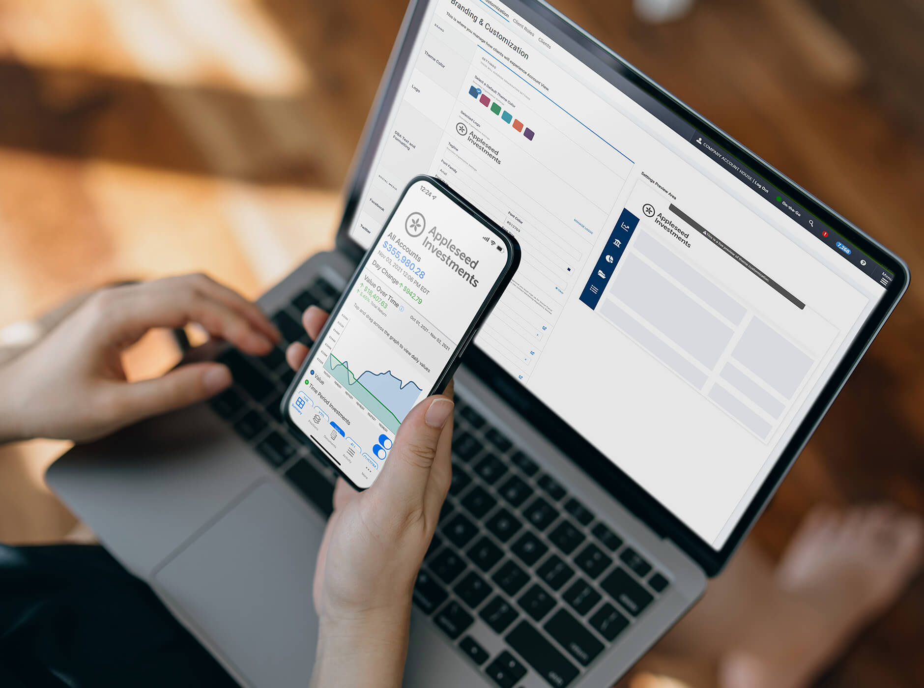 woman on laptop with mobile device in hand using stock app