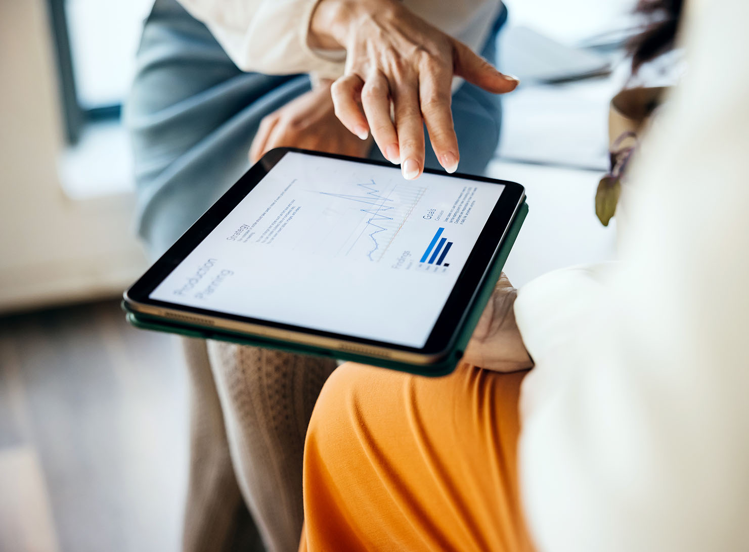 close up of two business colleagues using a digital tablet in office