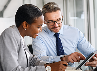 african american business woman, caucasian business man looking at tablet