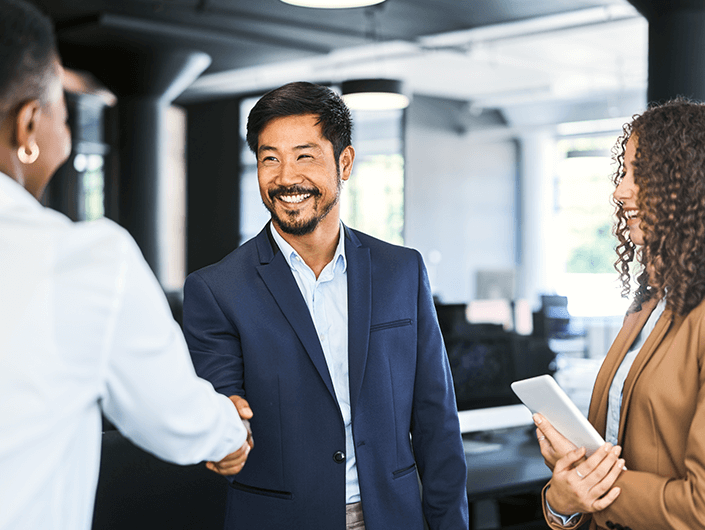 three people smiling and talking