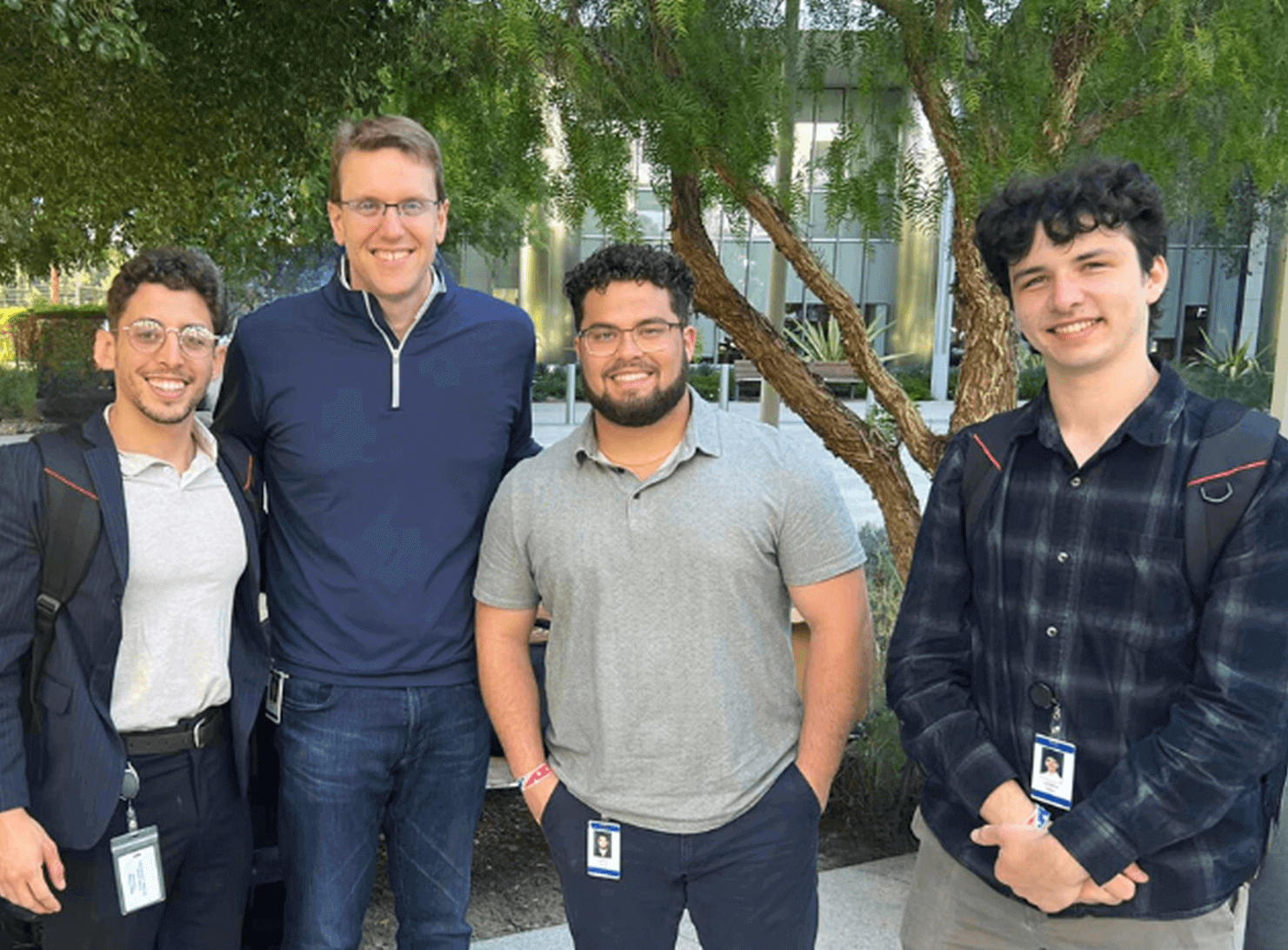  4 young male smn coworkers outside in front of lpl building