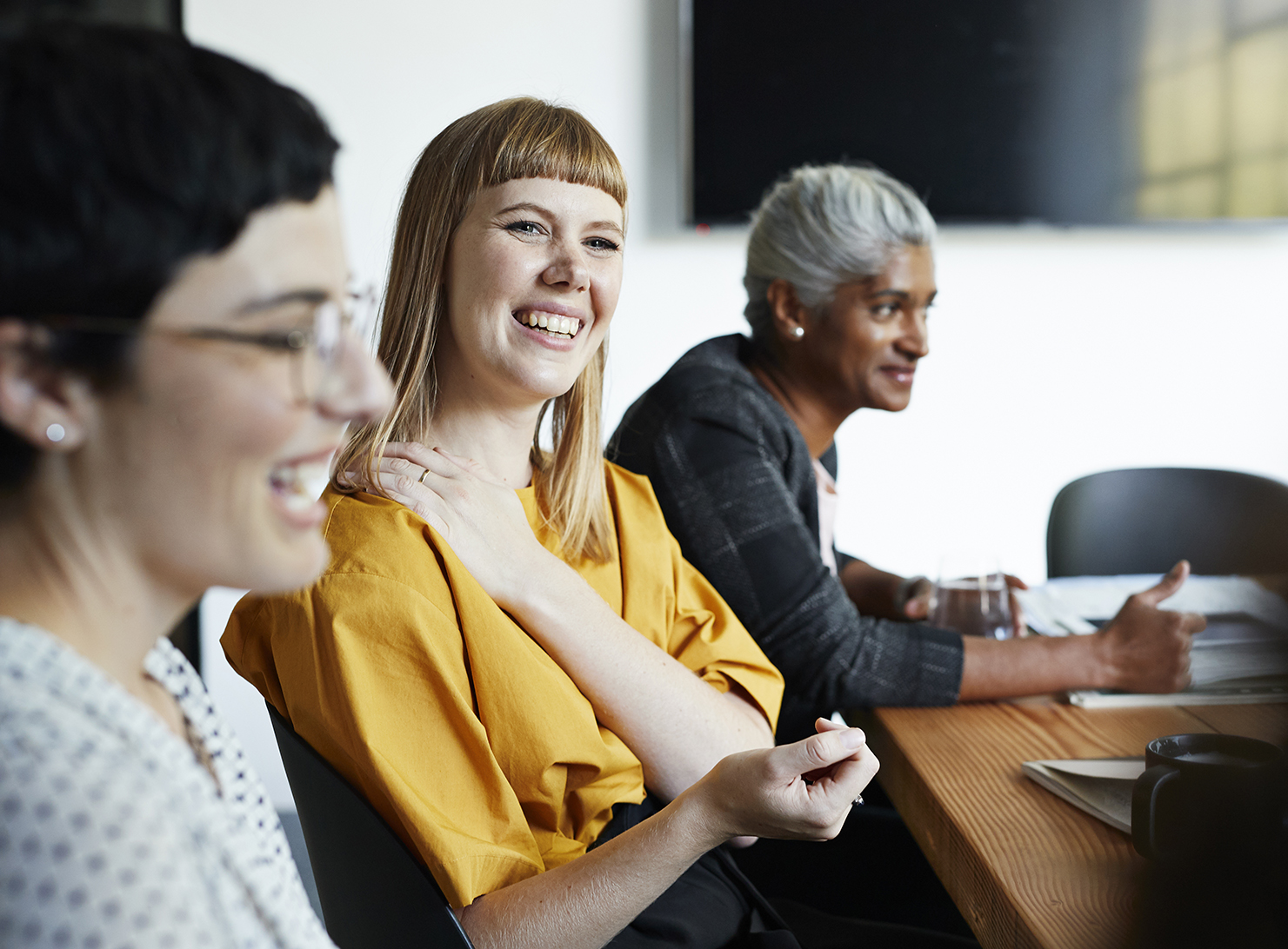 diverse multi-generational team seated at meeting table